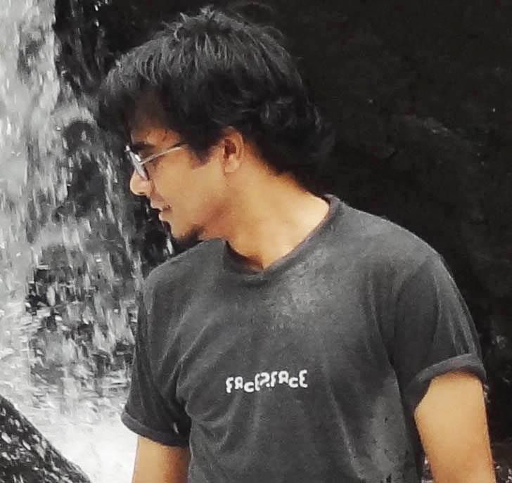 A younger Diwakar beside a waterfall